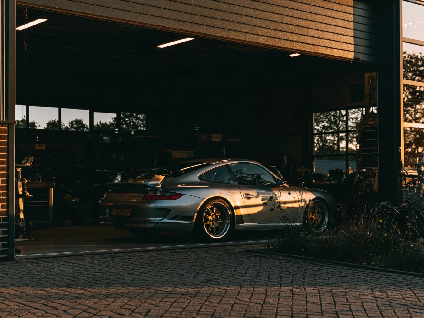 A 997 GT3 on the four-post ramp with its wheels off during a post-purchase inspection