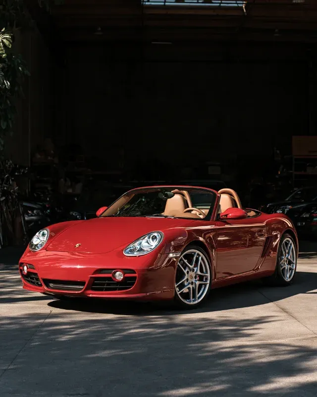 A guards red 987 Boxster S, roof down